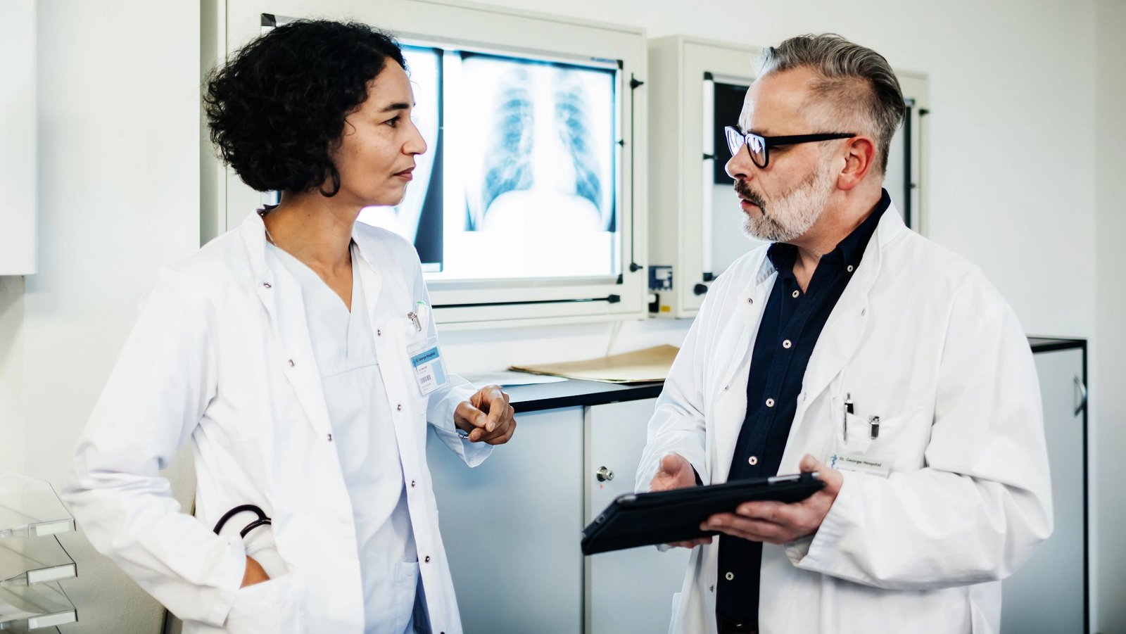 Arzt und Arztin tauschen sich über einen Patienten aus.