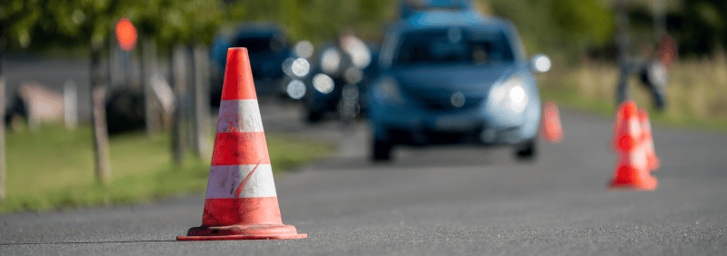 Auto fährt auf Straße, die tw. abgesperrt ist
