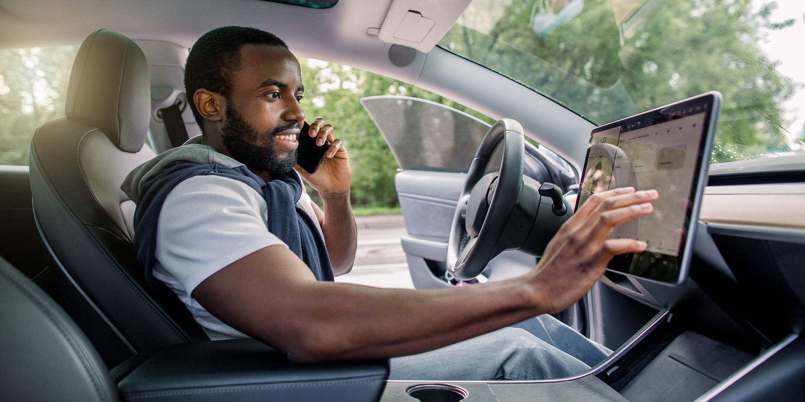 Mann  sitzt im Auto und gibt die Zieladresse ins Navi ein | Auto Überstellung
