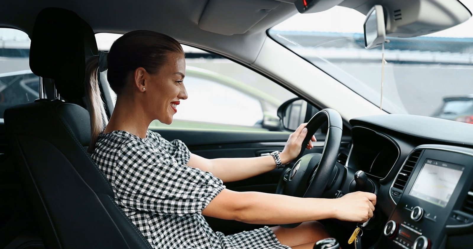 Eine Dame steckt den Schlüssel ins Zündschloss. 