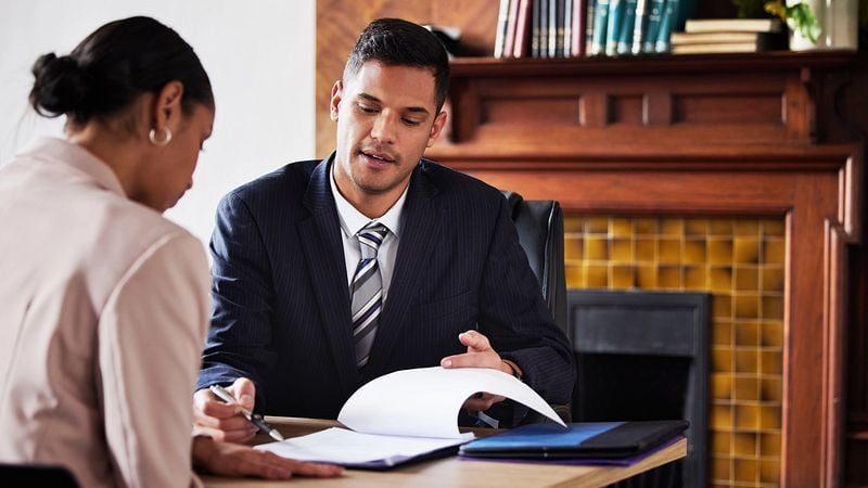 EIn Anwalt erklärt einer Dame die Vertragseinzelhieten.