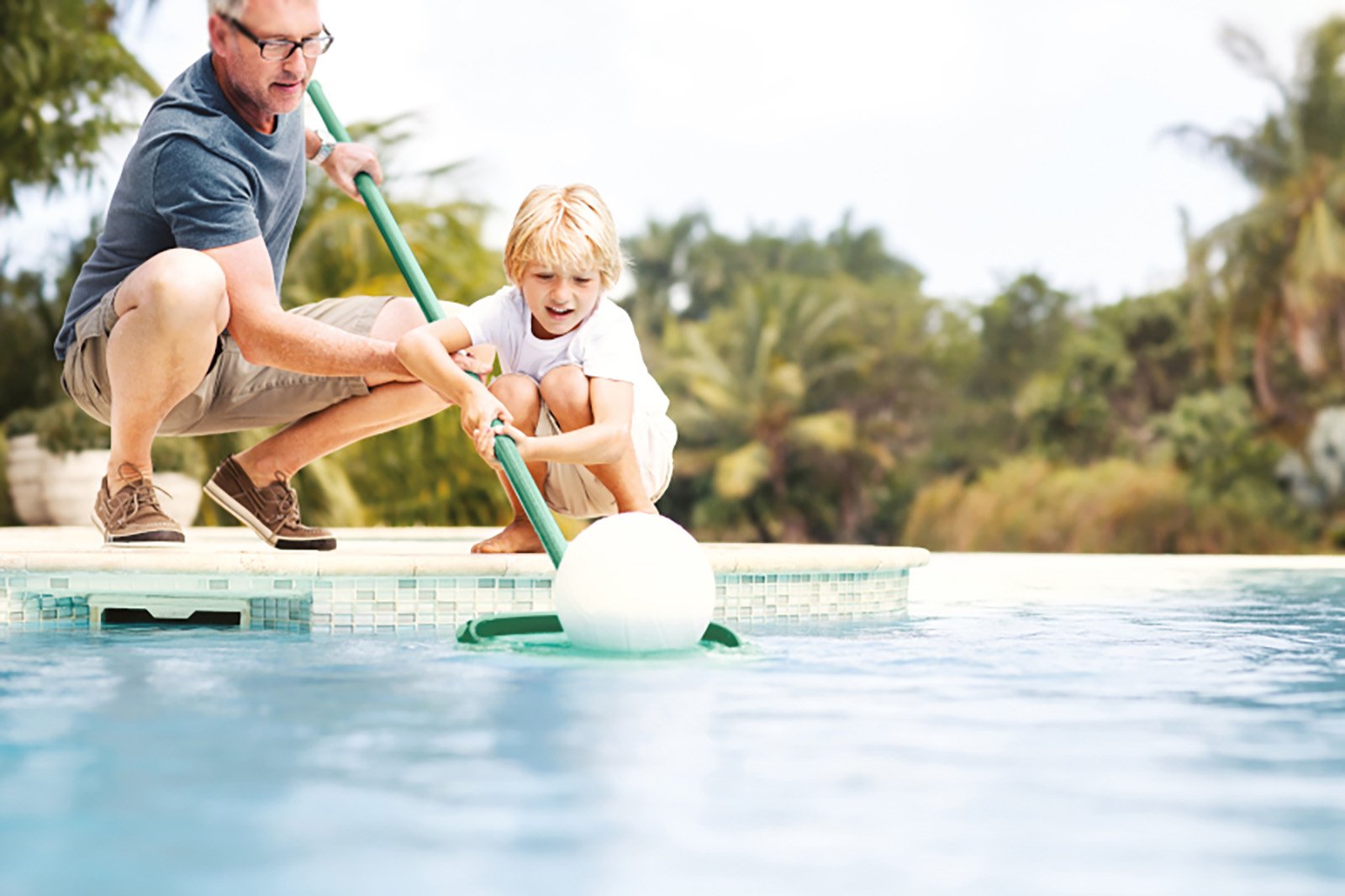 Vater und Kind fischen mit Kescher Schmutz aus dem Pool