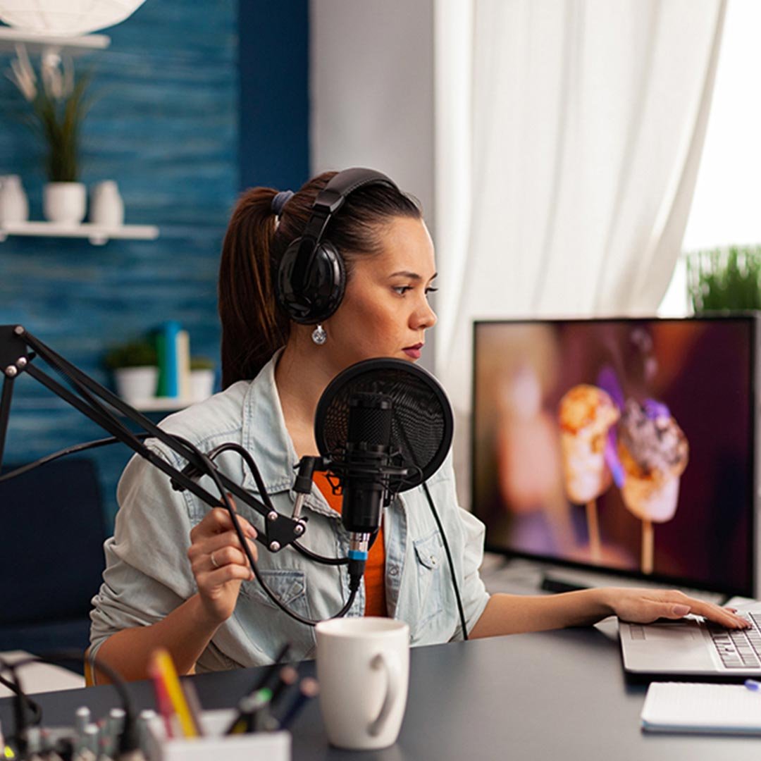 Eine Vloggerin sitzt vor dem Mikro und nimmt eine Sendung auf