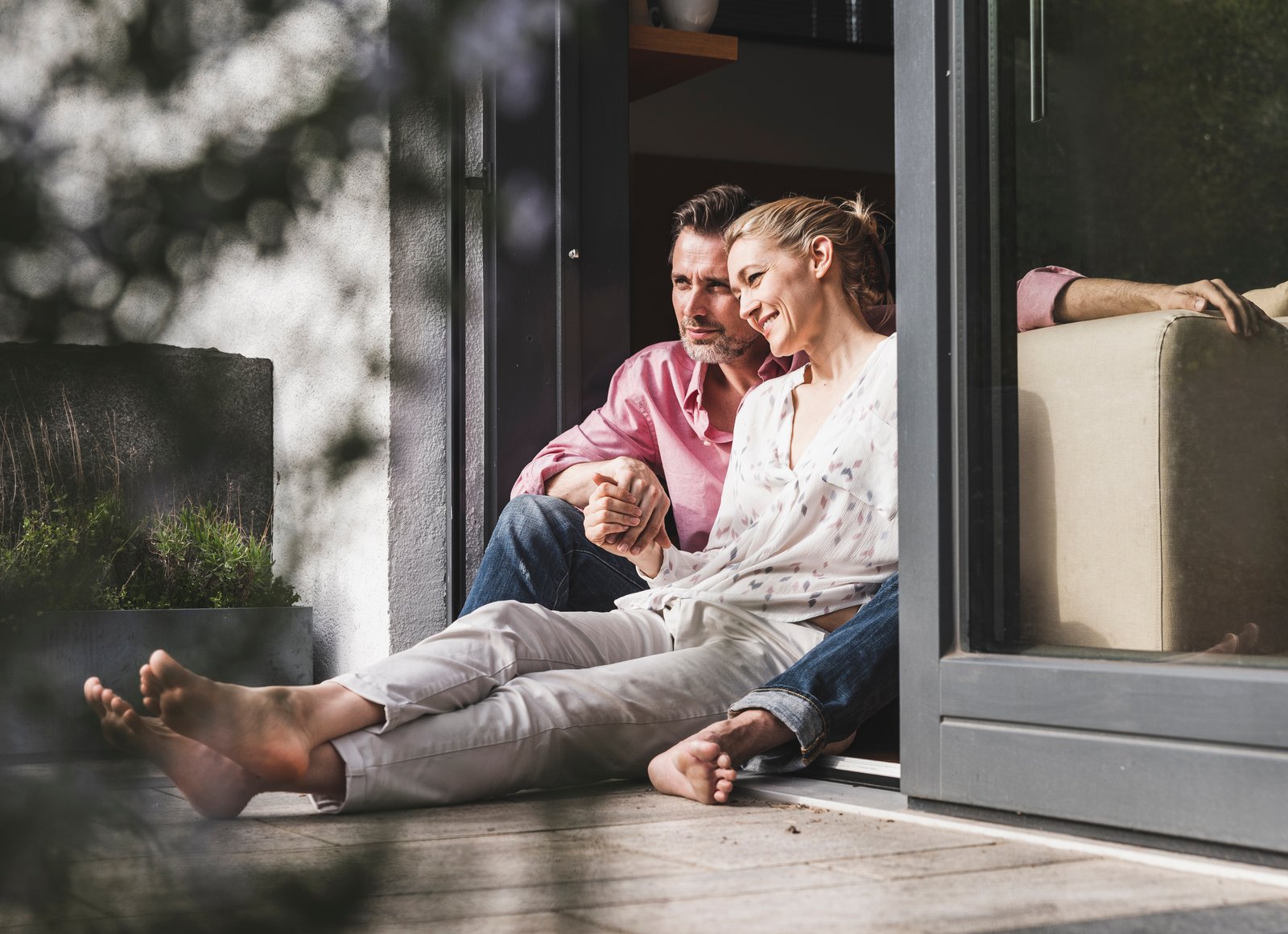 Pärchen sitzt auf der Terrasse und blickt ihrer Zukunft entspannt entgegen