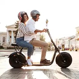 Frau und Mann sind mit E-Moped unterwegs
