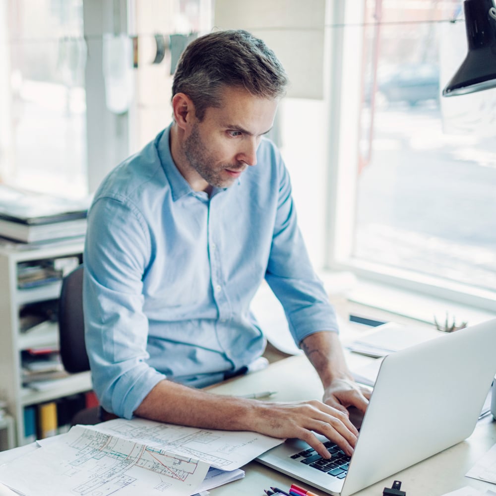 Unternehmer arbeitet am Laptop in seiner Firma